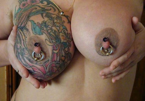 one tattoo titty and both pierced with brown nipples