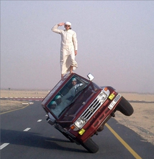 crazy guy on top of sideways car in saudi arabia