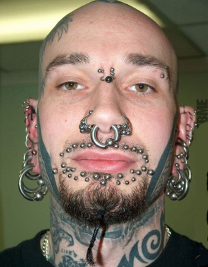tons of piercings on this guys face